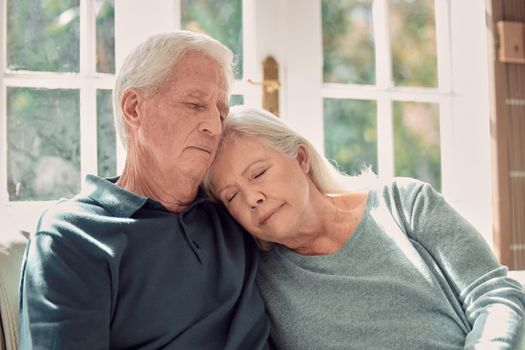 A shoulder to lean on. an affectionate senior couple sitting in their living room at home.