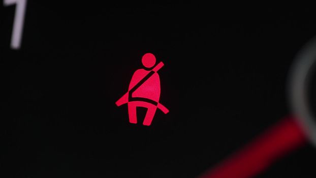 Car seat belt indicator lights on dashboard. Road safety regulations concept