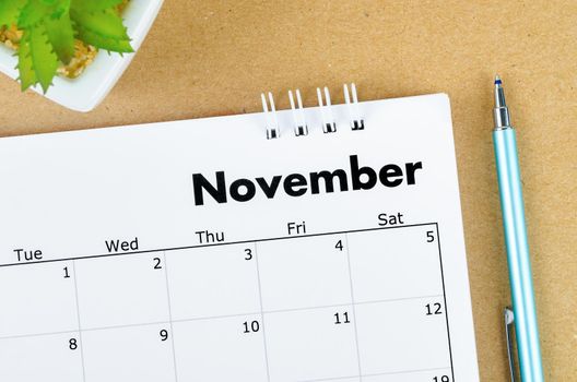 The November 2022 desk calendar on brown background.