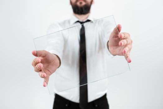 Male Corporate Holding Transparent Glass And Presenting Important Sales Data. Man Wearing Necktie Displaying New Ideas And Strategies For Achieving The Business Goals.