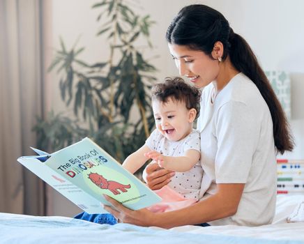 Mother reading to her baby. Parent reading a storybook. Happy woman reading to her child. Mother holding excited baby. Little girl excited by a story. Mother and daughter bonding.Baby happy about book