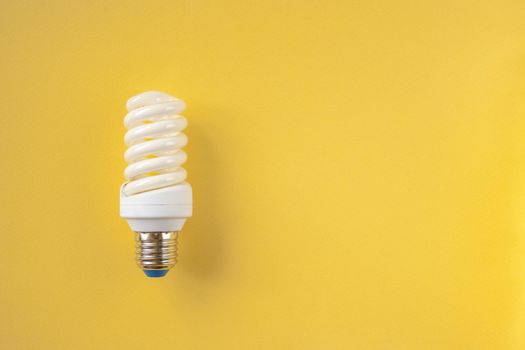 Energy saving light bulb on a yellow background