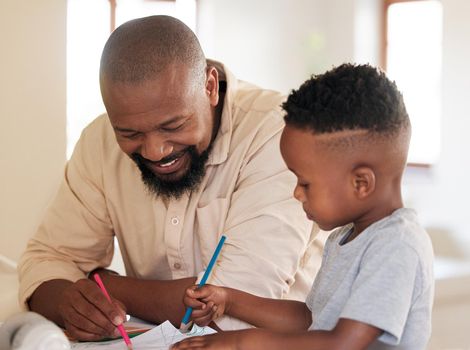 African american boy doing homework with his dad. A handsome black man helping his son with school work at home. Its important to learn and get an education. A parent and child working on a project
