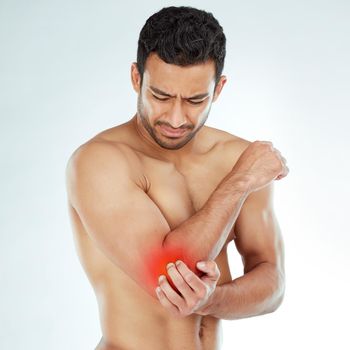 Points of pain and pressure. a man clutching his elbow in pain against a studio background.