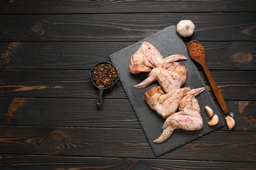 Marinated chicken wings on a rustic wooden background.