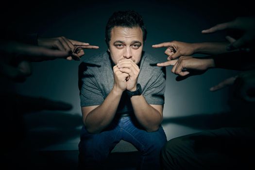 One mixed race male suffering mental illness in asylum. Caucasian schizophrenic man experiencing a breakdown while being surrounded by people on a stage theatre performance