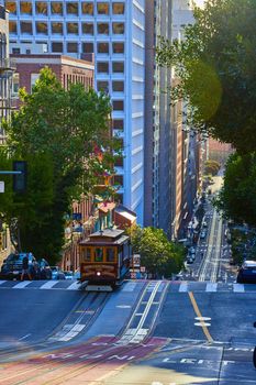 Trolley over San Francisco wavy roads through skyscrapers in morning