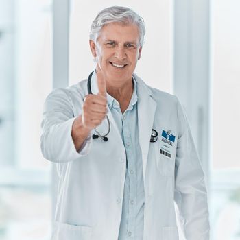 A good physician is such a blessing. Portrait of a mature doctor showing thumbs up in a hospital.