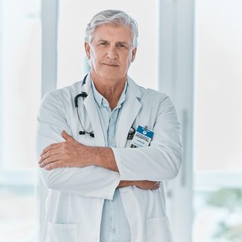 His years of experience counts in his favour. Portrait of a mature doctor standing with his arms crossed in a hospital.