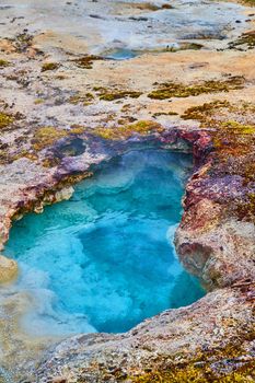 Vibrant blue alkaline thermal pool at Yellowstone in basin