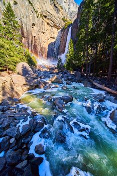 Yosemite Lower Falls in early morning with frosty rocks and icy river