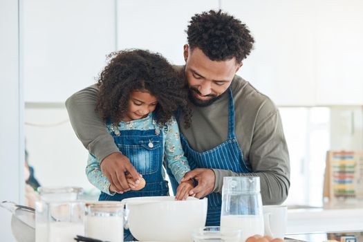 Daddy and daughter time. a handsome young man and his daughter baking in the kitchen at home.