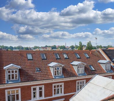 Oldwindow. Rooftop view of buildings in a town with glass windows and frames under a cloudy blue sky. Beautiful landscape architecture with clouds surrounding a suburban urban environment.