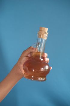 holding a apple vinegar glass bottle