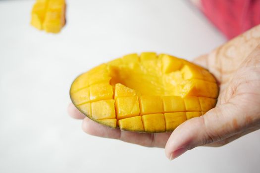 young women eating slice of a mango