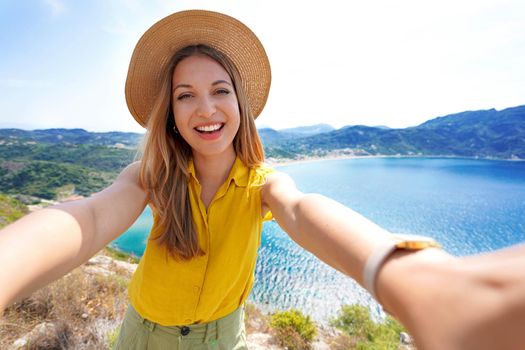 Beautiful happy traveler girl makes selfie while traveling in the mountains. Summer adventure and vacations.