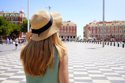 Tourism in France. Back view of young tourist woman walking in Massena square in Nice, France.
