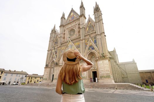 Holidays in Italy. Tourist woman enjoying view the well reserved Cathedral of Orvieto, Umbria, Italy.