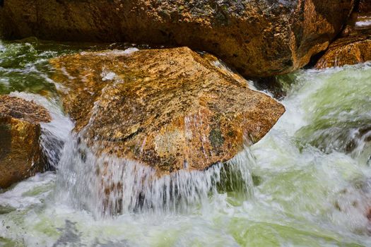 Water pouring in river over outcropping of rock