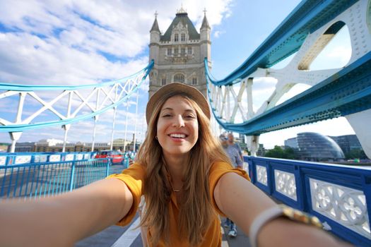 Smiling girl takes selfie photo on Tower Bridge in London, United Kingdom