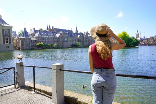 Tourism in Holland. Young traveler girl looking at the complex of buildings of Binnenhof in The Hague, Netherlands.