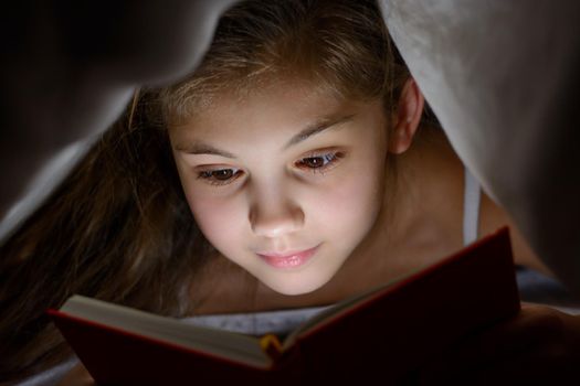 Beautiful caucasian child is eager to read interesting stories before bedtime