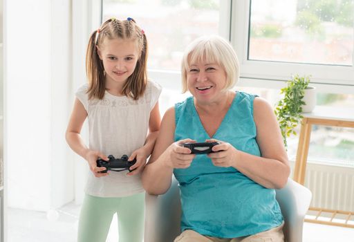 Woman playing video game with granddaughter