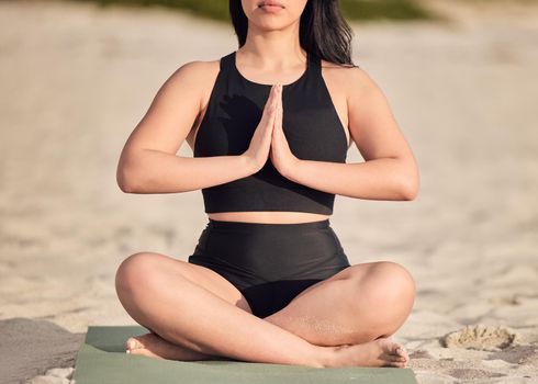 Yoga is the opportunity to be curious about who you are. an unrecognisable woman meditating at the beach.