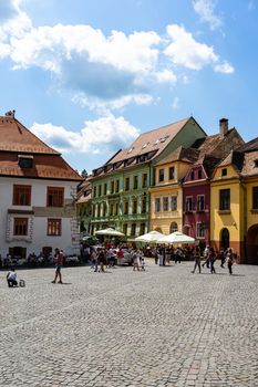 People and tourists wantering in old citadel of Sighisoara, Romania, 2022
