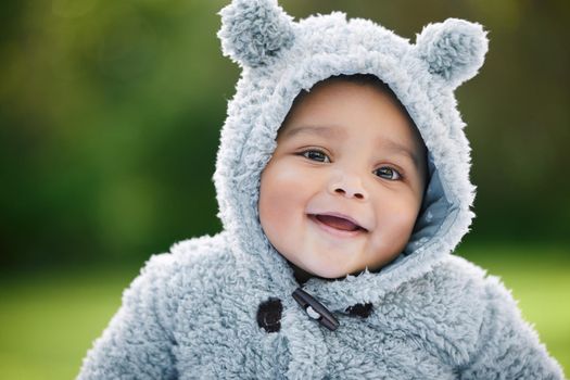 Hes unbearably cute. Portrait of an adorable baby boy wearing a furry jacket with bear ears outdoors.