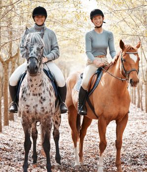 There is no better place. two attractive young women horse riding on a farm.