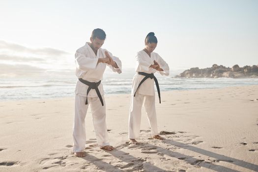 A fighter must have honour. Full length shot of two young martial artists practicing karate on the beach.