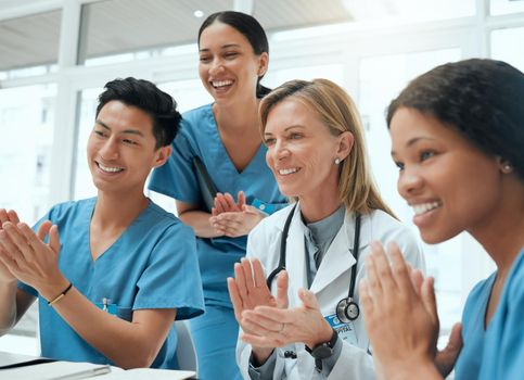 Every achievement deserves an applause. a group of doctors clapping hands in a meeting at work.