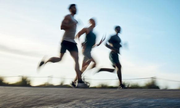Go for a run. Blurred shot of three athletic young men running together.
