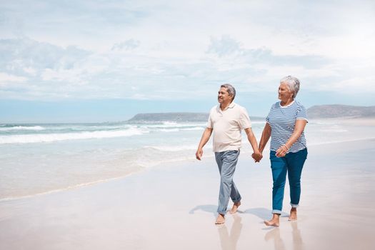 Nothing feels better than a walk on the beach. a senior couple taking a walk on the beach.