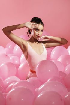 girly like you like it. Studio shot of a beautiful young woman posing with balloons.