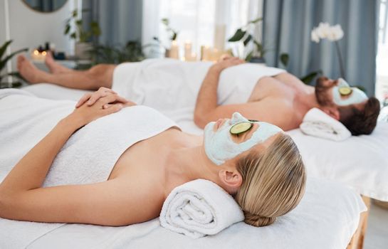Dont forget to pamper yourself. a young couple wearing cucumbers on their eyes in a spa.