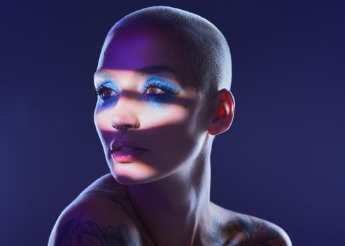I rather be true to myself than hide my authenticity. Studio shot of an attractive young woman wearing edgy makeup against a blue background.