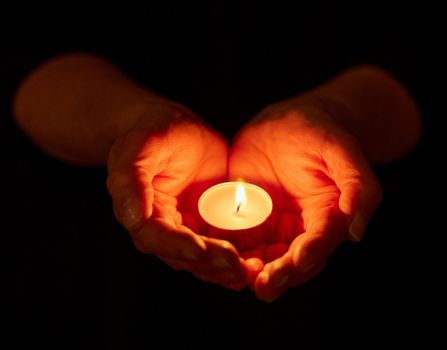 We have always held to the hope. a unrecognizable person holding a candle in the dark.