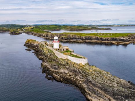 Aerial of the Rotten Island Lighthouse with Carntullagh Head in background - County Donegal - Ireland