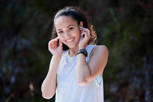 Music is what gets me going. a sporty young woman wearing earphones while out for her workout.