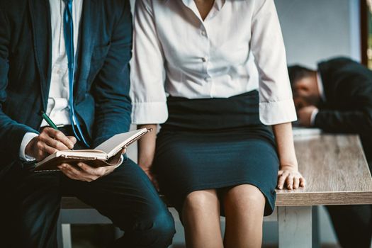Knees Of Business Man And Woman Sitting On Office Desk