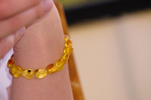 Amber bracelet on woman hand close up view