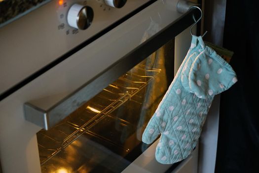 Pan holder oven glove hand on the oven close up view