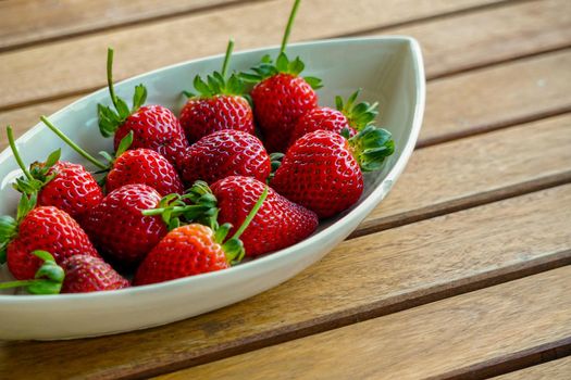Freshly harvested strawberries on wooden background with copyspace