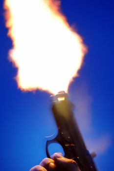 Gun blast pulling the trigger at night close up view