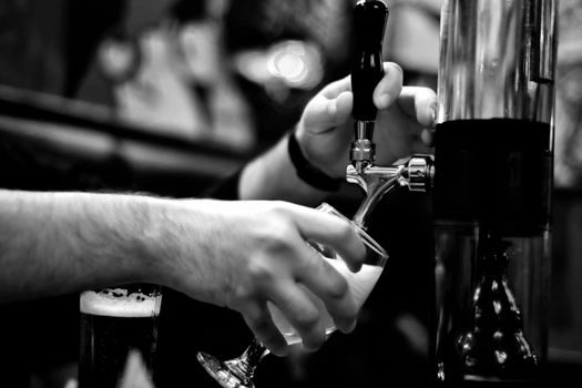 Beer faucet and pint in the pub black and white close up view