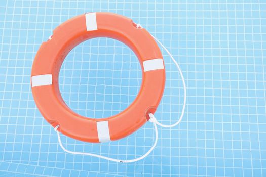 Red safety equipment floating on swimming pool to rescue people from drowning
