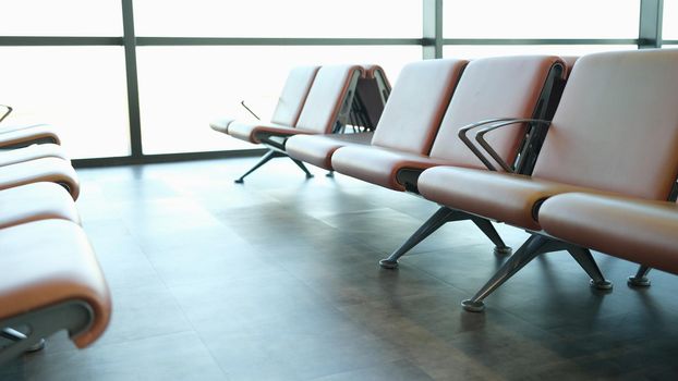 Location in airport terminal. Leather light brown armchairs at station station