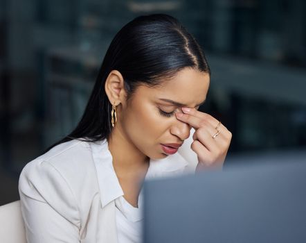 How am I going to recover from this. an attractive young businesswoman sitting alone in her office at night and feeling stressed while using her computer.